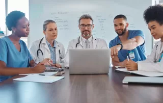 healthcare talent team at a hospital looking and discussing information on a laptop