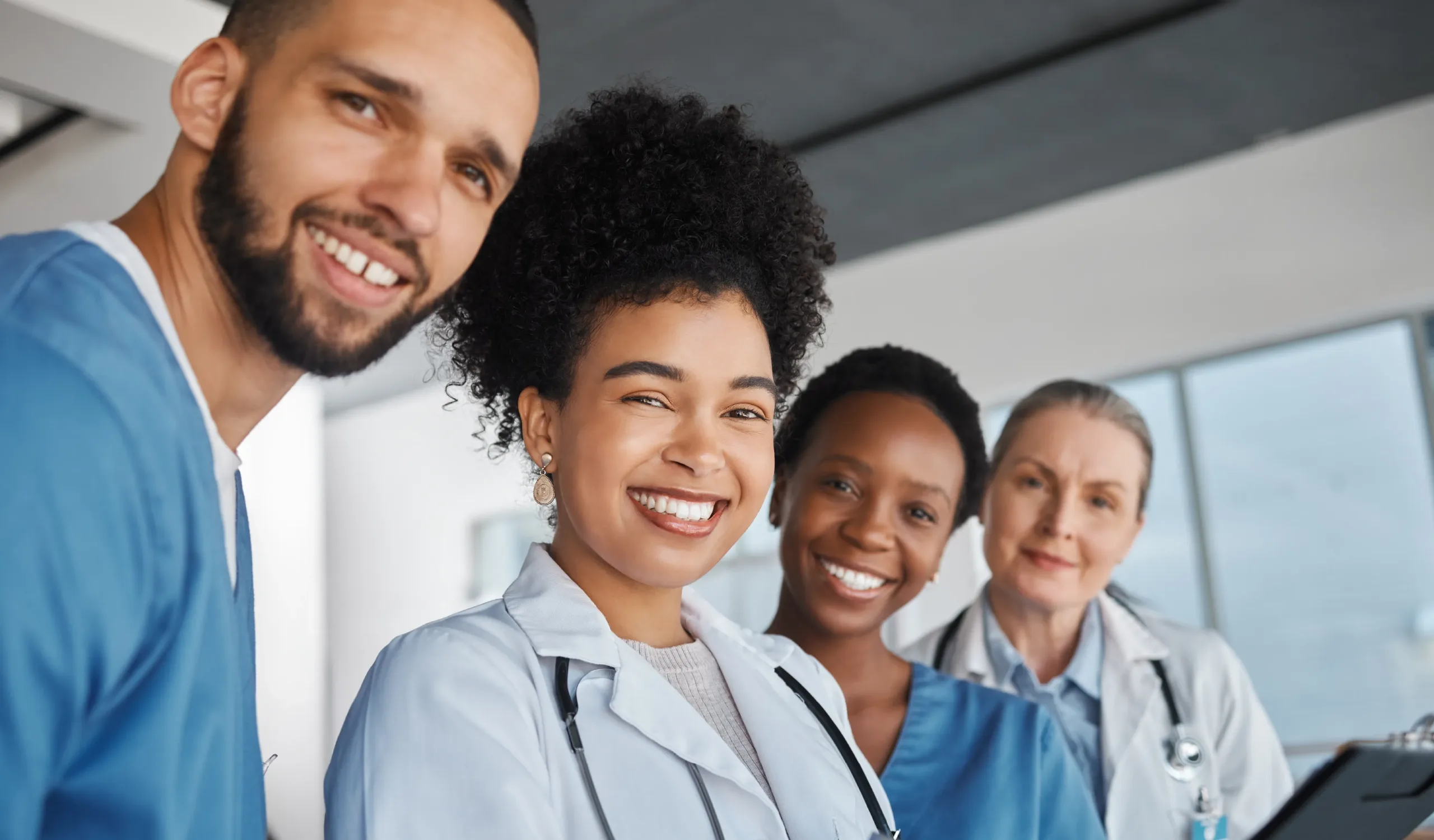 a group of doctors and nurses working in the healthcare industry in blue slacks looking for job recruitment smile at the camera